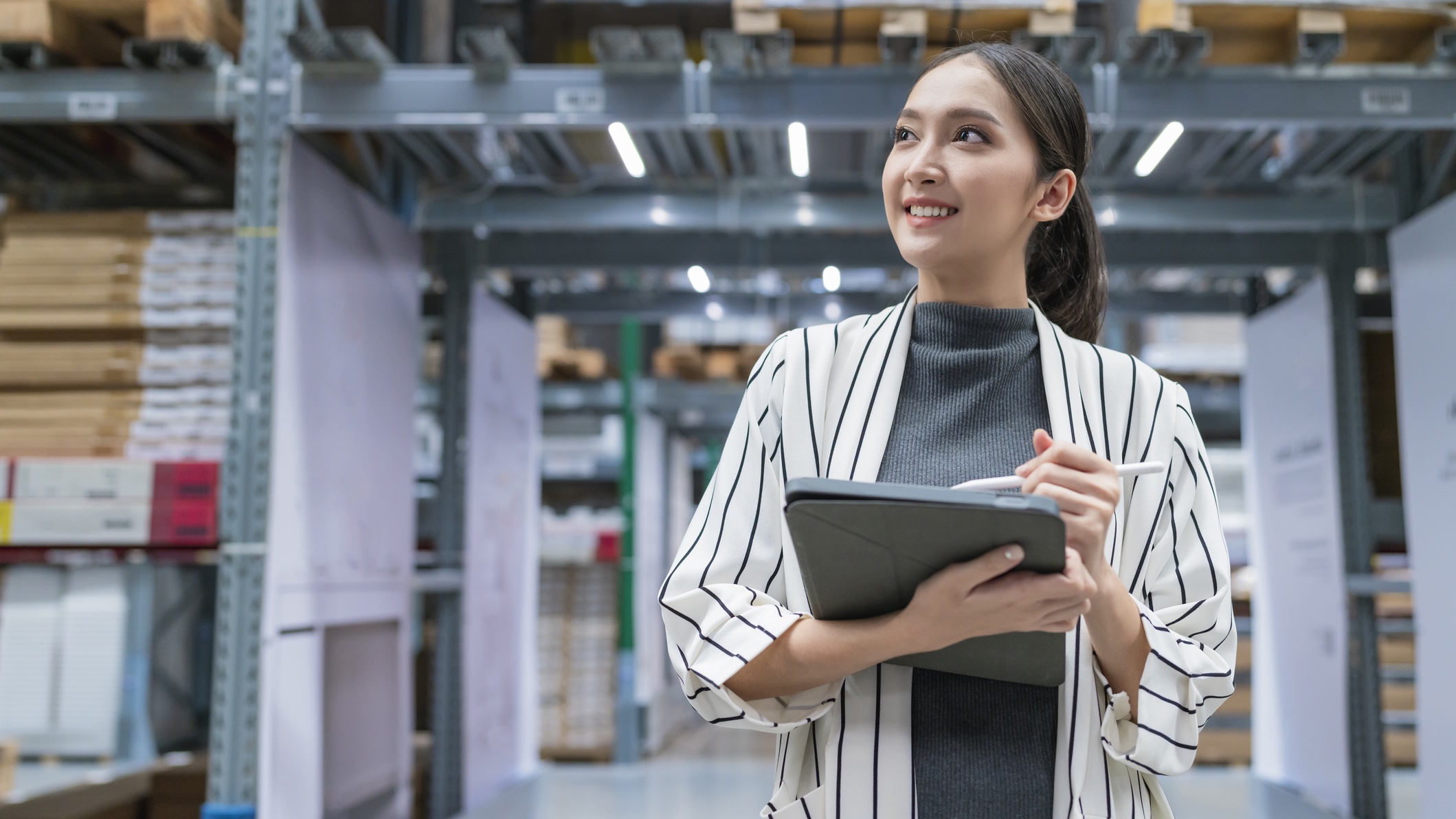 Woman smiling and checking inventory on tablet